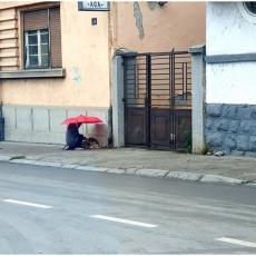 FOTOGRAFIJA KOJA JE SVE DIRNULA U SRCE: Dečak kleknuo pored psa i pustio ga pod svoj kišobran (FOTO)