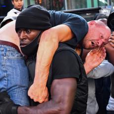 SLIKA DANA DOLAZI IZ LONDONA: Afroamerikanac poneo belca preko ramena (FOTO)