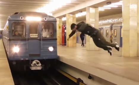 (VIDEO) PLES SA SMRĆU: Preskočio šine saltom, tik ispred voza... ZASTRAŠUJUĆE!